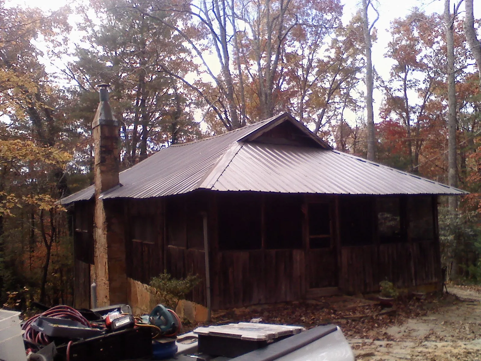 Brown metal hip roof on an old cabin with a stone chimney in La Verkin