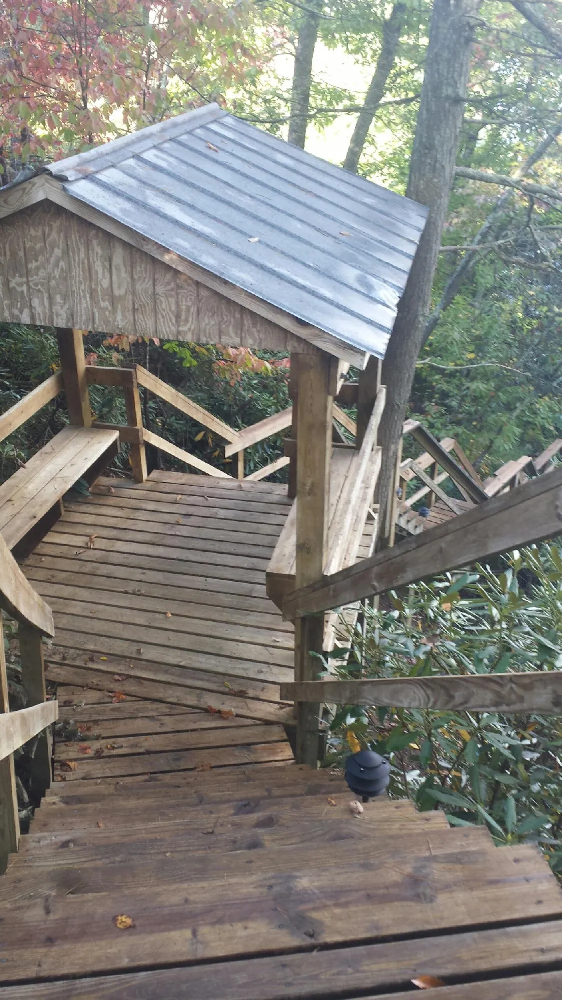 Metal roofed shelter over wooden steps on a wooded walkway — Skylight Repair & Installation work by our crew in La Verkin