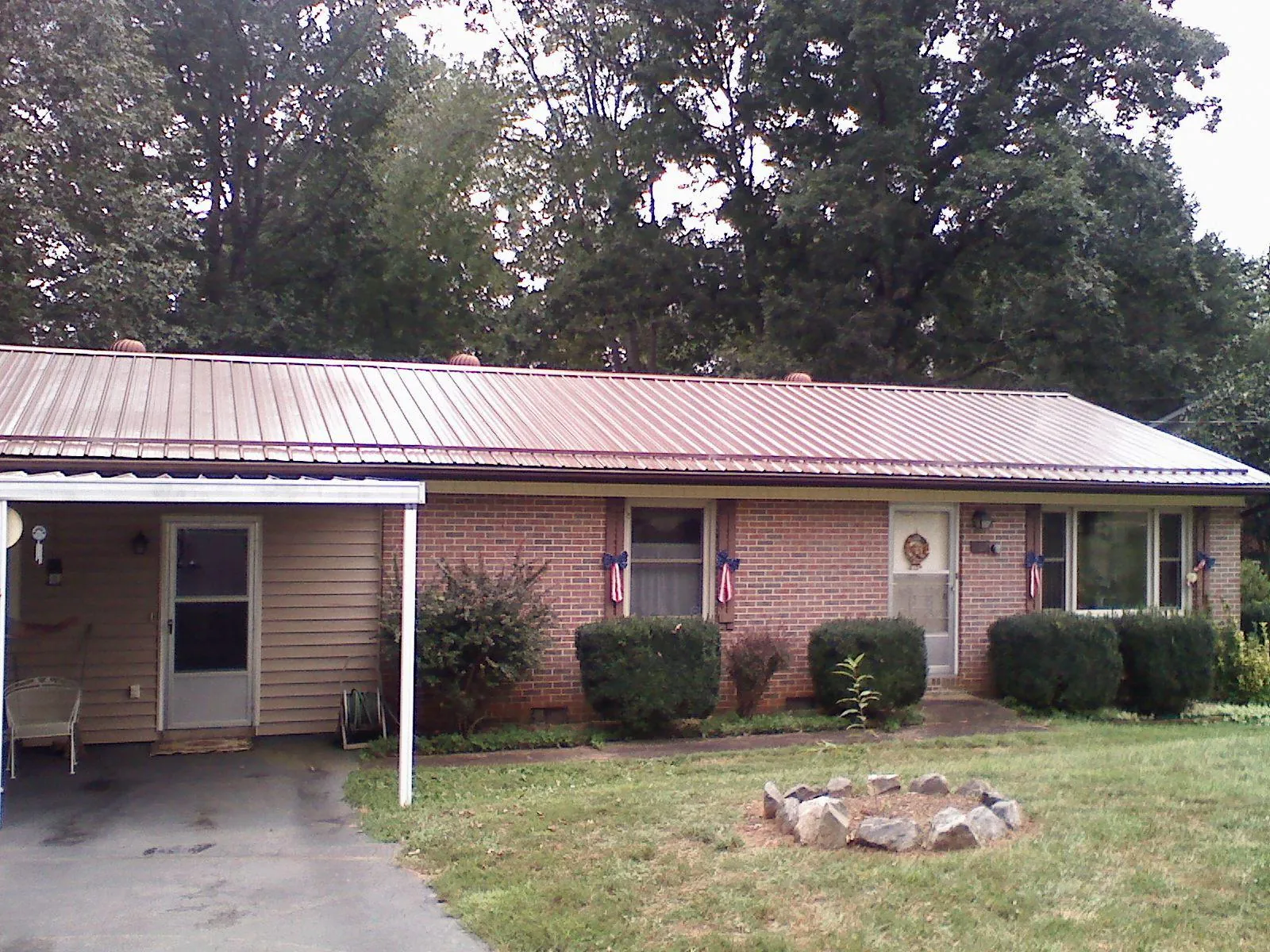 Bronze metal roof and carport on a brick ranch home — Roof Repair work by our crew in La Verkin